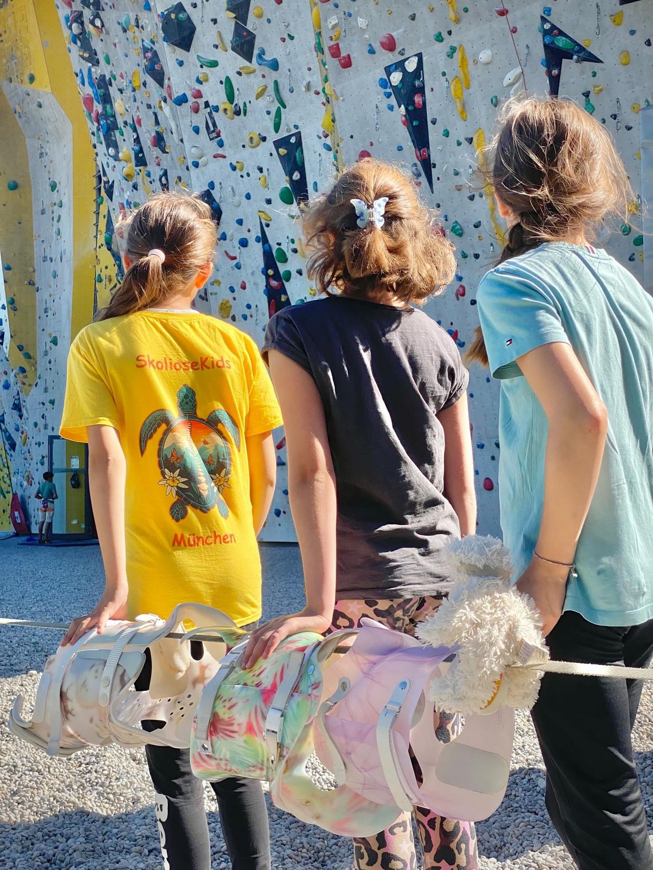 Kinder vor einer Kletterwand