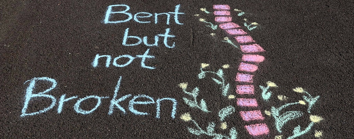 Zeichnung einer Wirbelsäule mit Text "Bent but not Broken"