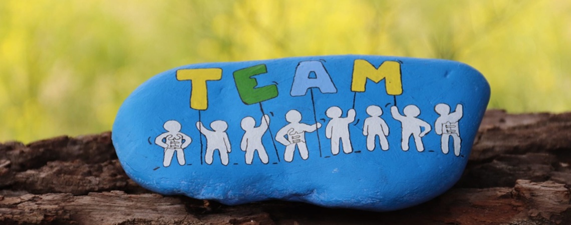 Buntbemalter Stein mit dem Wort Team Buntbemalter Stein mit dem Wort Team