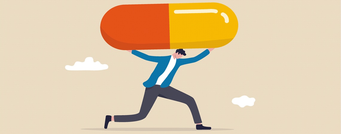 Mann trägt übergroße Schmerztablette auf Schulter