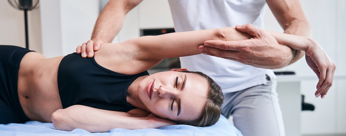 eine junge Frau wird von einem Physiotherapeuten behandelt eine junge Frau wird von einem Physiotherapeuten behandelt