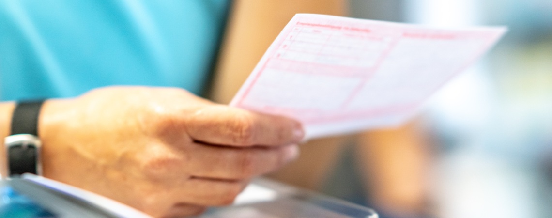 Arzt hält in der rechten Hand ein Rezept